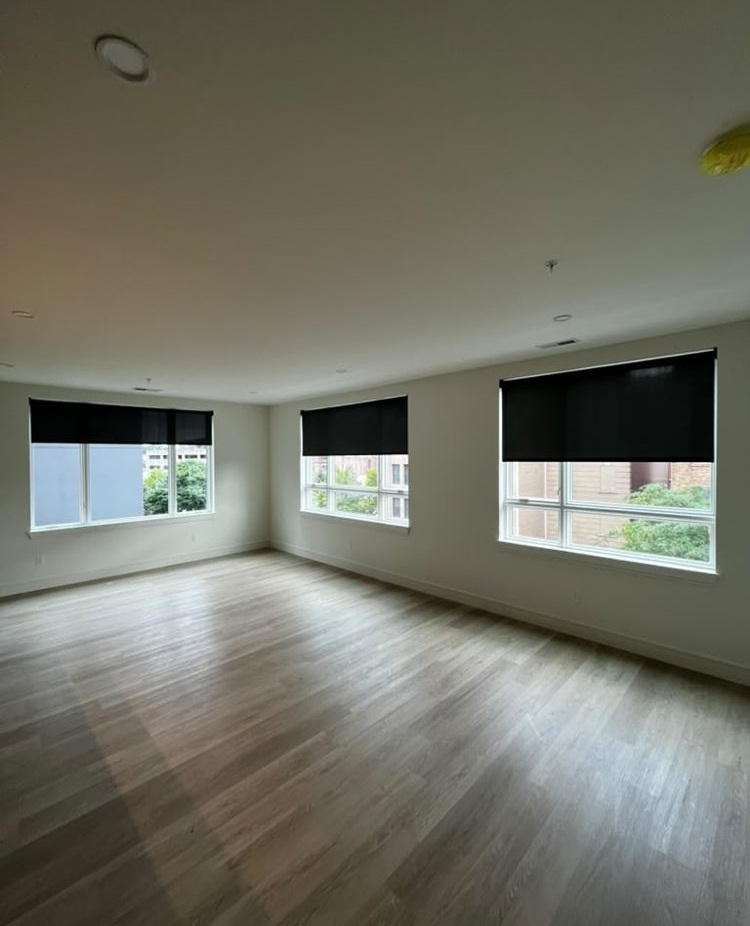 Roller shades across three windows in an empty room